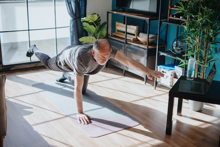 Senior man doing balance exercise drills in his living room