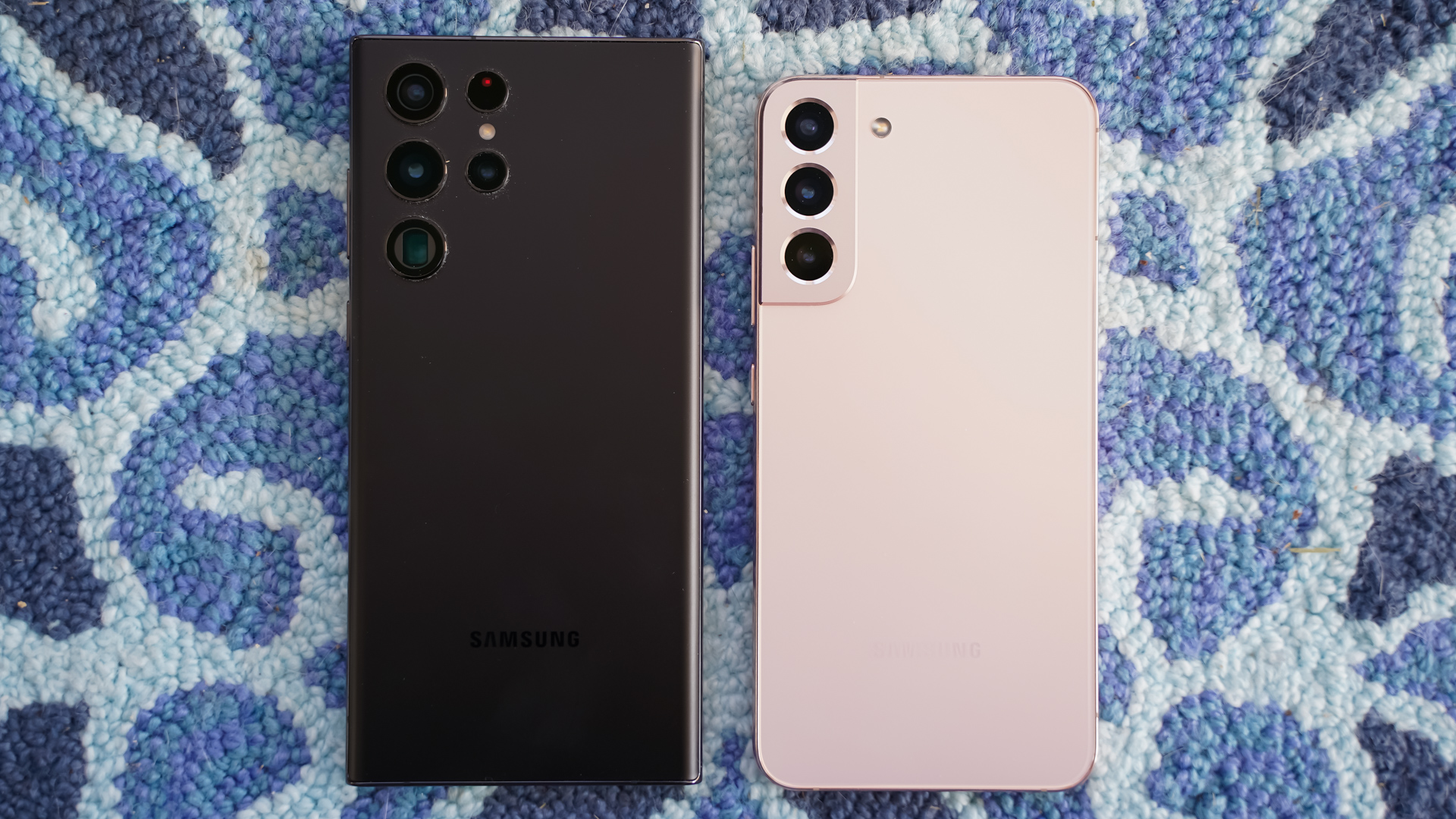 Samsung Galaxy S22 Ultra black vs Samsung Galasy S22 Plus pink rear on carpet